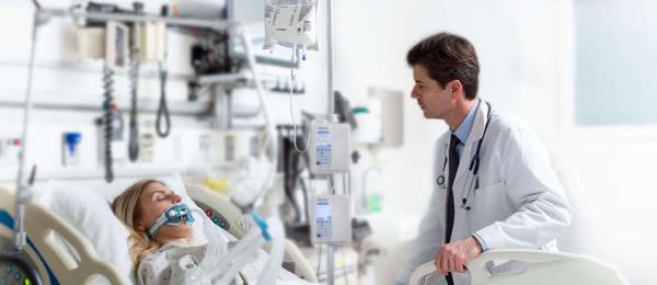 Doctor sitting with patient in hospital bed